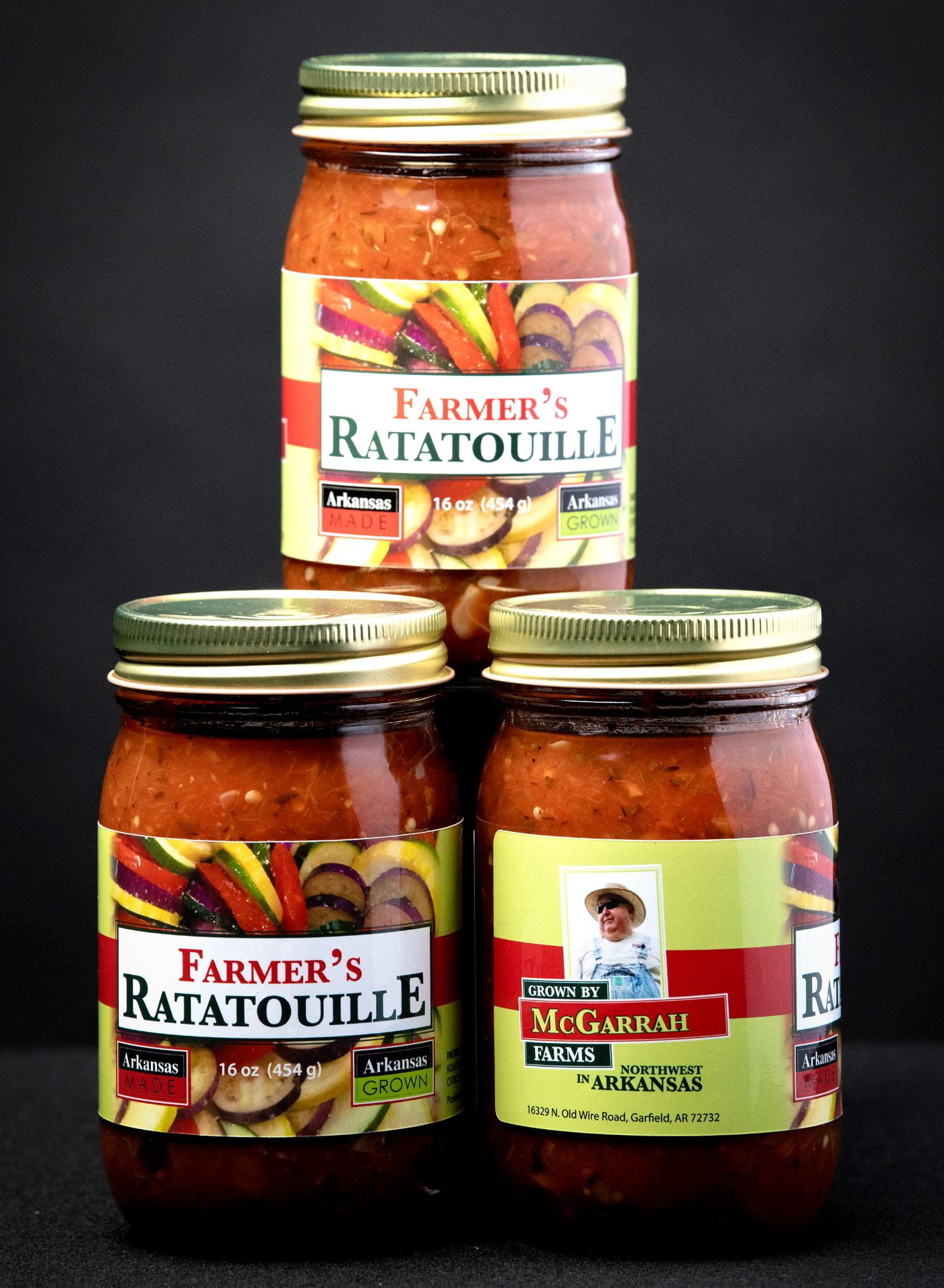 Stack of three jars of a product called Farmer's Ratatouille in front of a black background