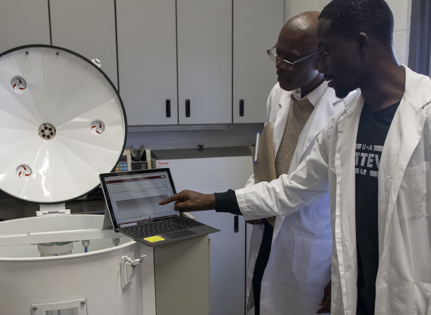 CARBON DIOXIDE SENSORS — Griffiths Atungulu, left, director of the Rice Processing Program, works with Samuel Olaoni, Ph.D. student, on a miniature grain bin to test carbon dioxide sensors for monitoring grain quality. (U of A System Division of Agriculture photo)